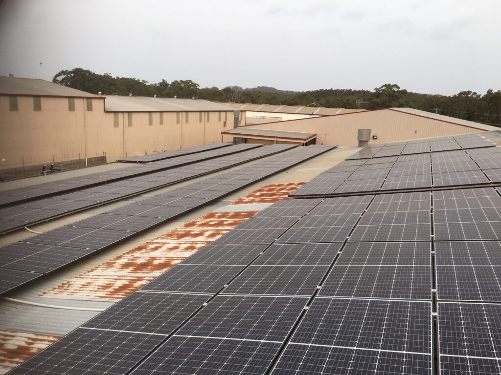 A large solar panel array on the roof of an industrial building.