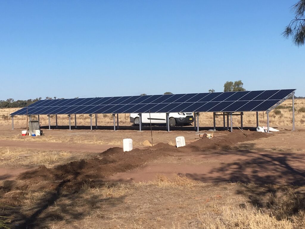 A truck parked in front of a solar array.