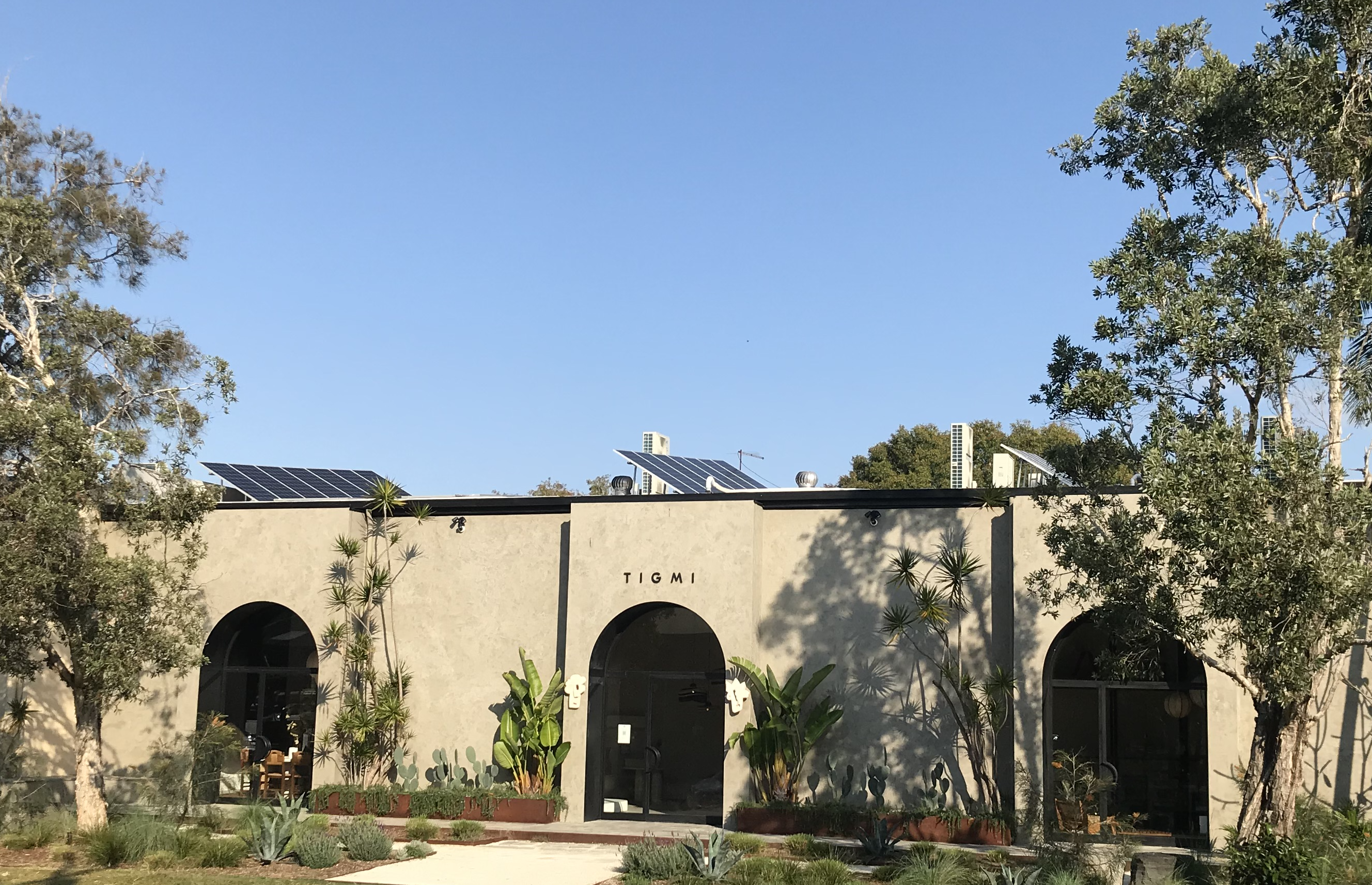 A building with a large arch and a solar panel on the roof.